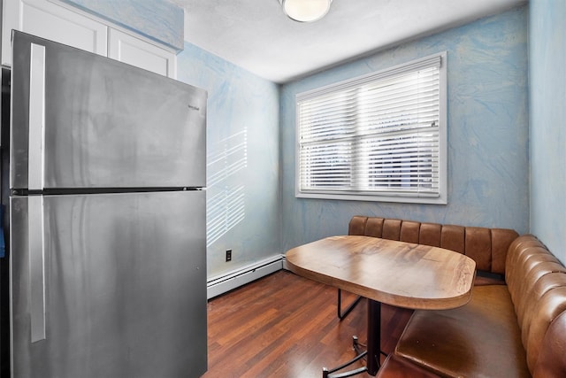 interior space with dark wood finished floors and a baseboard heating unit