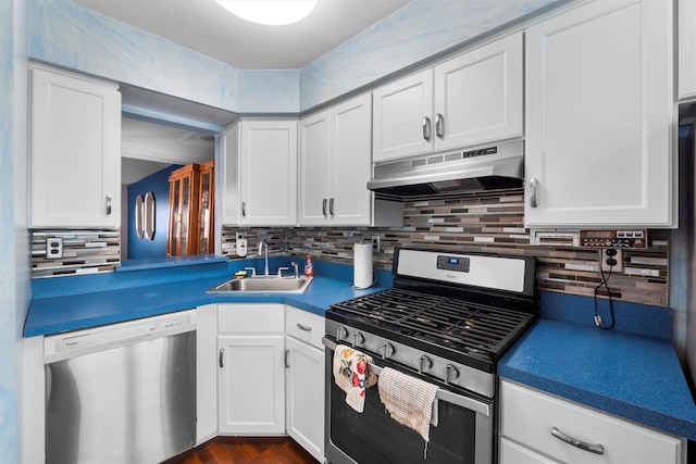 kitchen with backsplash, under cabinet range hood, appliances with stainless steel finishes, white cabinets, and a sink