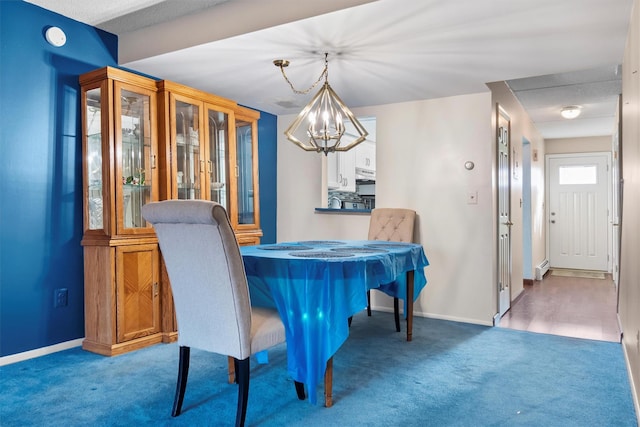 carpeted dining room featuring an inviting chandelier and baseboards