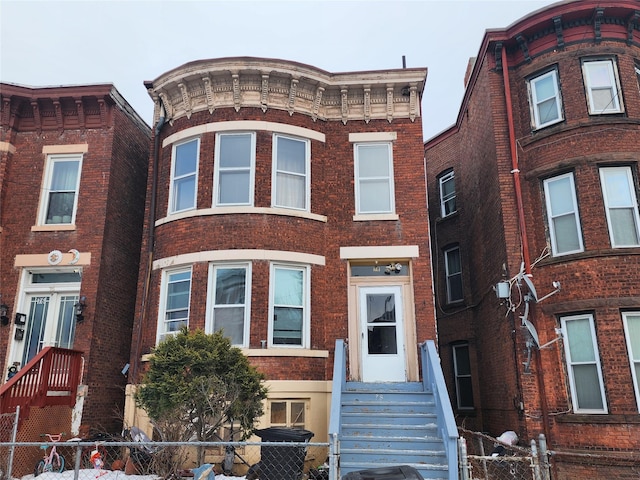 italianate house with a fenced front yard and brick siding