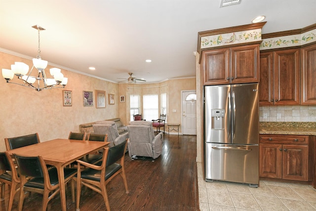 dining space featuring light wood-style floors, recessed lighting, ornamental molding, and ceiling fan with notable chandelier