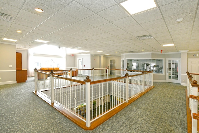 hallway with carpet floors, baseboards, and visible vents