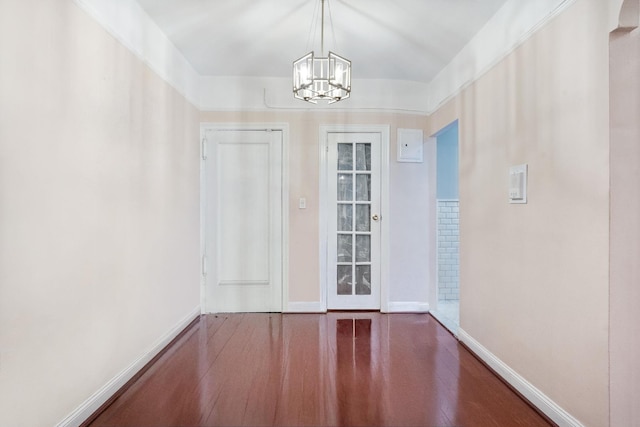 entryway featuring a notable chandelier, baseboards, and wood finished floors