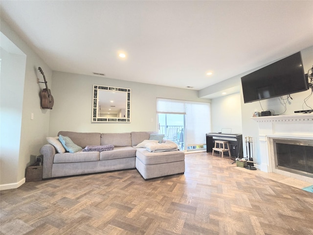 living room with a fireplace with flush hearth, baseboards, and recessed lighting