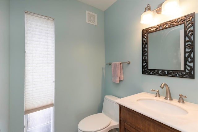 bathroom featuring visible vents, vanity, and toilet