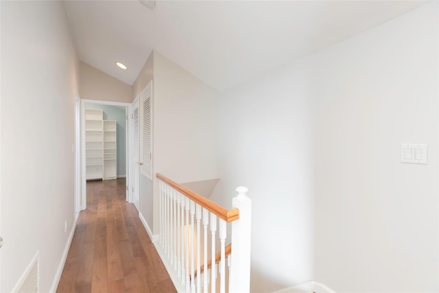 hall featuring recessed lighting, visible vents, vaulted ceiling, an upstairs landing, and wood finished floors