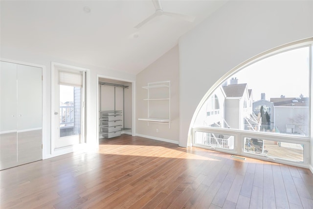 interior space featuring high vaulted ceiling, wood finished floors, visible vents, and baseboards