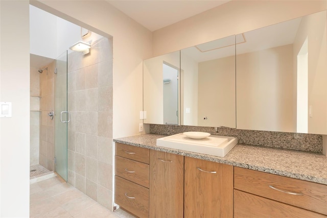 bathroom with a stall shower, tile patterned flooring, and vanity