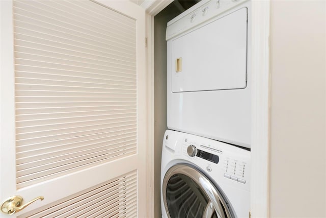 clothes washing area with stacked washer / dryer and laundry area