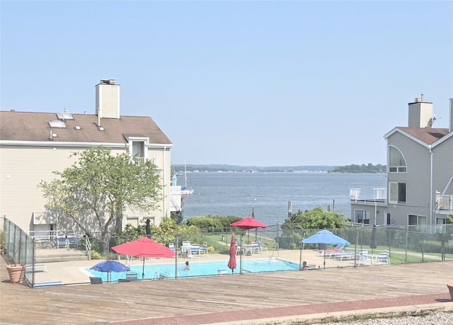 surrounding community featuring a water view and fence