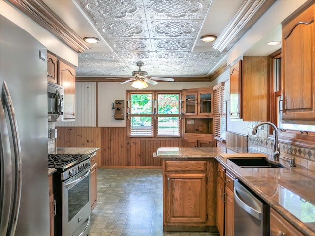 kitchen with an ornate ceiling, stainless steel appliances, brown cabinetry, a sink, and a peninsula