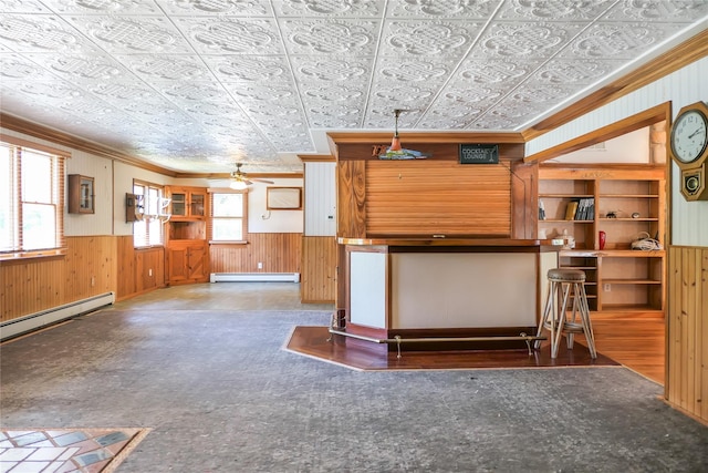 kitchen featuring a baseboard heating unit, wood walls, wainscoting, and an ornate ceiling