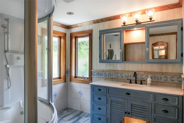 full bathroom with a stall shower, tile walls, and vanity