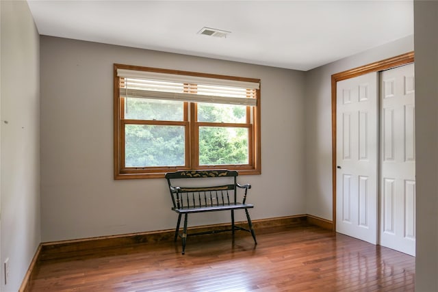 living area featuring dark wood-style floors, visible vents, and baseboards