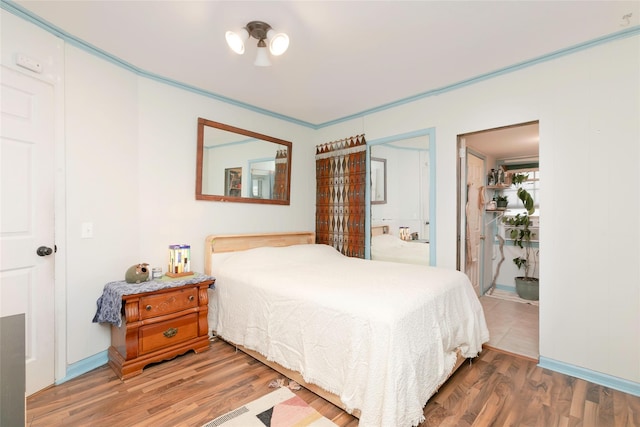 bedroom with wood finished floors and connected bathroom