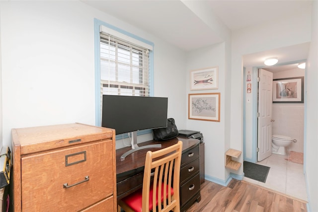office area with tile walls and light wood-style floors