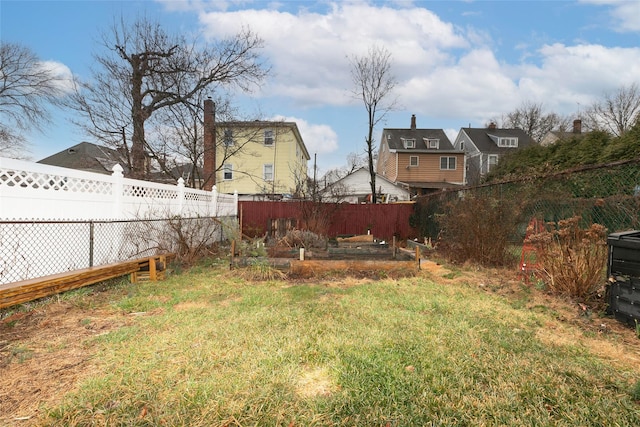 view of yard with a fenced backyard and a garden