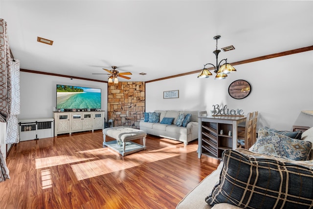 living room featuring ceiling fan with notable chandelier, wood finished floors, visible vents, radiator heating unit, and crown molding