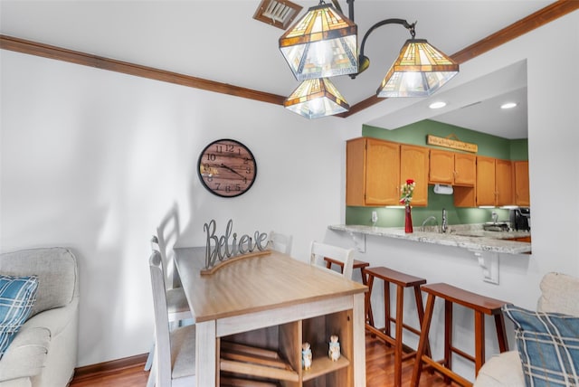 dining space with light wood finished floors, baseboards, crown molding, and recessed lighting