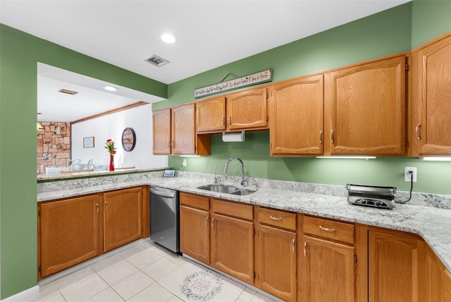 kitchen with visible vents, stainless steel dishwasher, brown cabinetry, a sink, and light stone countertops