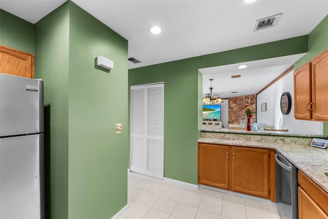 kitchen with stainless steel appliances, brown cabinetry, and visible vents