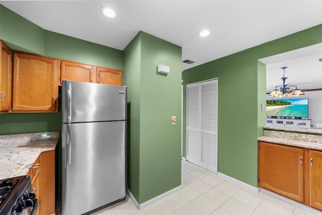 kitchen with visible vents, range, baseboards, freestanding refrigerator, and recessed lighting