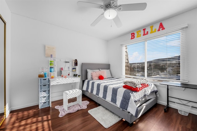 bedroom with a ceiling fan, dark wood finished floors, and baseboards