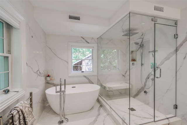 full bathroom featuring marble finish floor, visible vents, and a freestanding bath