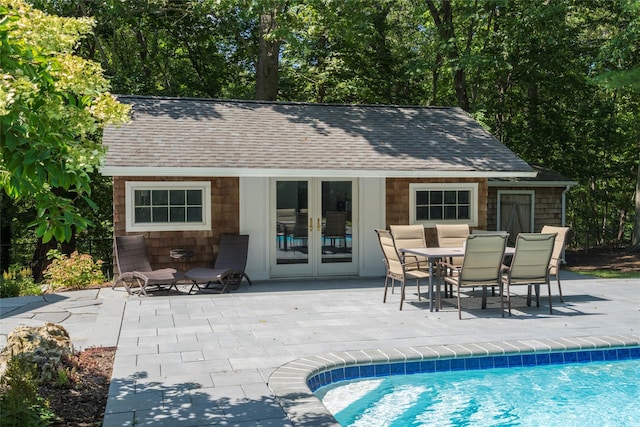 exterior space featuring outdoor dining area, an outdoor structure, a patio, and a storage structure