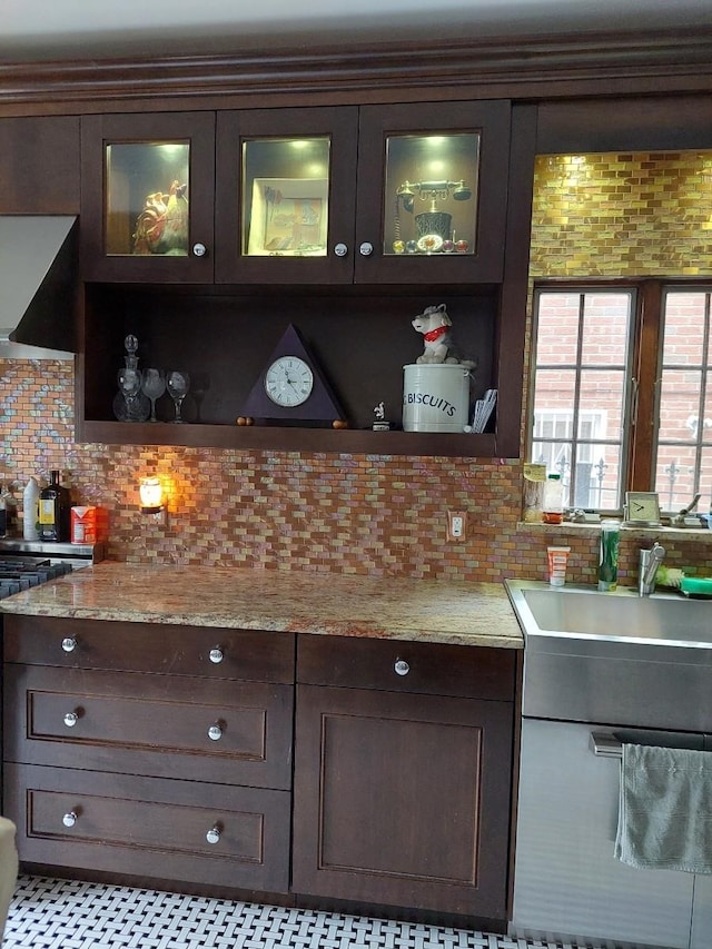 bar featuring wall chimney exhaust hood, stove, tasteful backsplash, and a sink