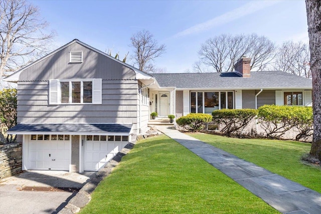 view of front of house featuring a front yard, roof with shingles, a chimney, driveway, and an attached garage