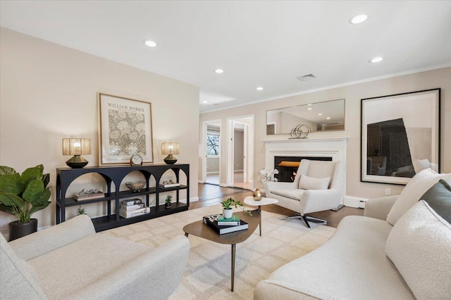 living area featuring wood finished floors, recessed lighting, visible vents, and ornamental molding