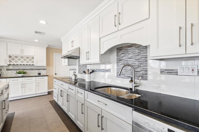 kitchen featuring visible vents, backsplash, under cabinet range hood, white cabinets, and a sink