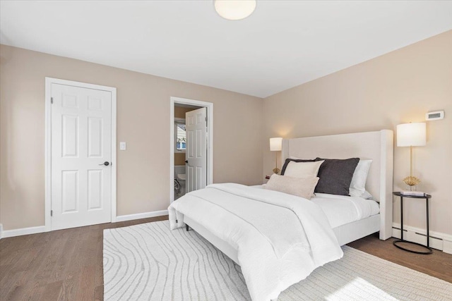 bedroom featuring wood finished floors, baseboards, and a baseboard radiator