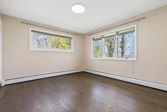 spare room featuring wood finished floors and baseboard heating