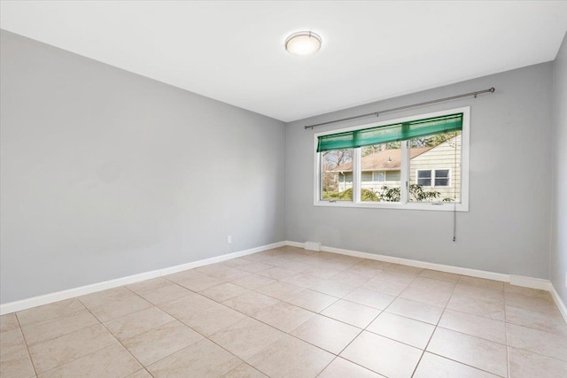 unfurnished room featuring light tile patterned floors and baseboards