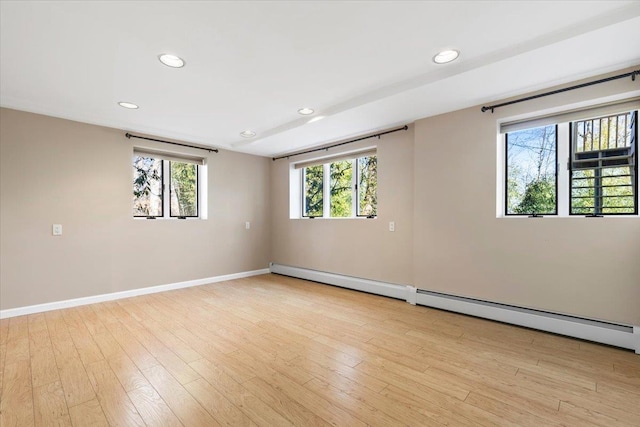 unfurnished room featuring a baseboard heating unit, light wood-style flooring, recessed lighting, and baseboards