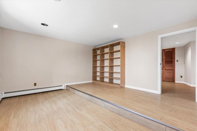 empty room with recessed lighting, a baseboard heating unit, baseboards, and wood finished floors