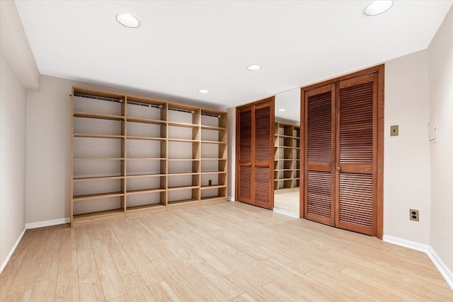 spare room featuring recessed lighting, baseboards, and wood finished floors