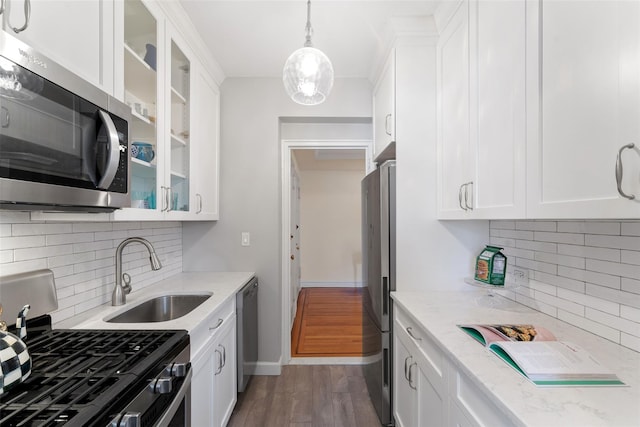 kitchen featuring appliances with stainless steel finishes, white cabinets, a sink, and glass insert cabinets