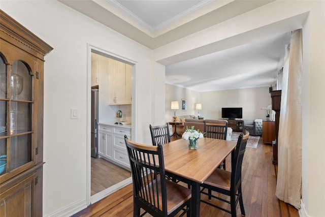 dining area featuring ornamental molding, baseboards, and hardwood / wood-style flooring