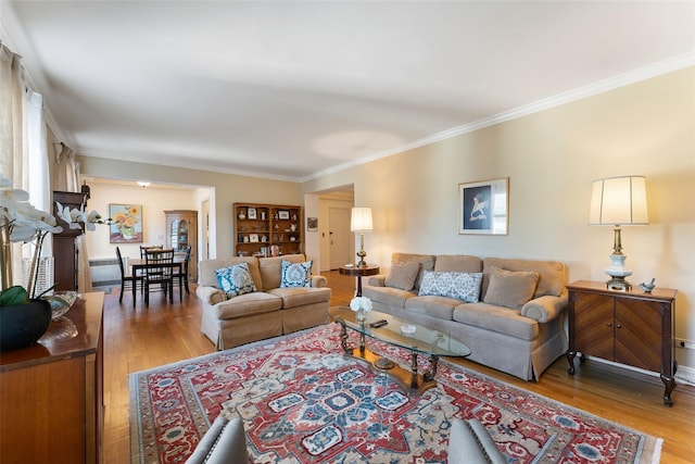 living area featuring ornamental molding and wood finished floors