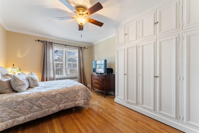 bedroom featuring radiator, light wood finished floors, and a ceiling fan