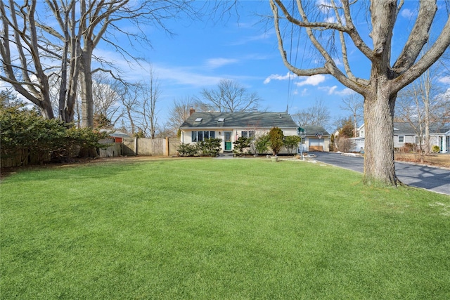 view of yard with driveway and fence