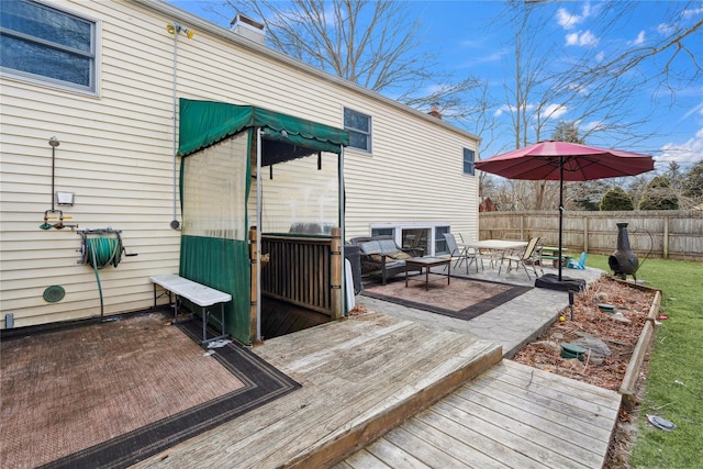 wooden terrace with a patio area and fence