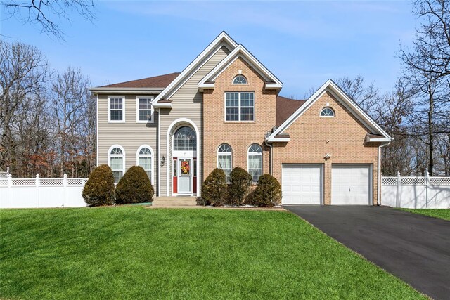 view of front of home with driveway, fence, and a front lawn