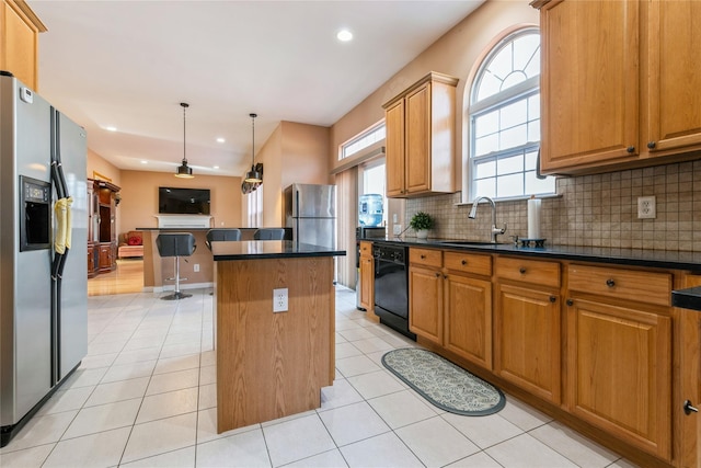 kitchen featuring stainless steel fridge, black dishwasher, dark countertops, a kitchen island, and freestanding refrigerator