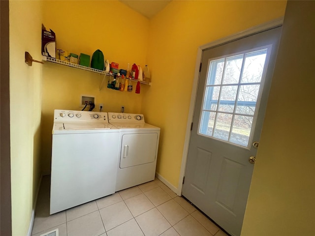 laundry area with laundry area, washer and clothes dryer, baseboards, and light tile patterned floors