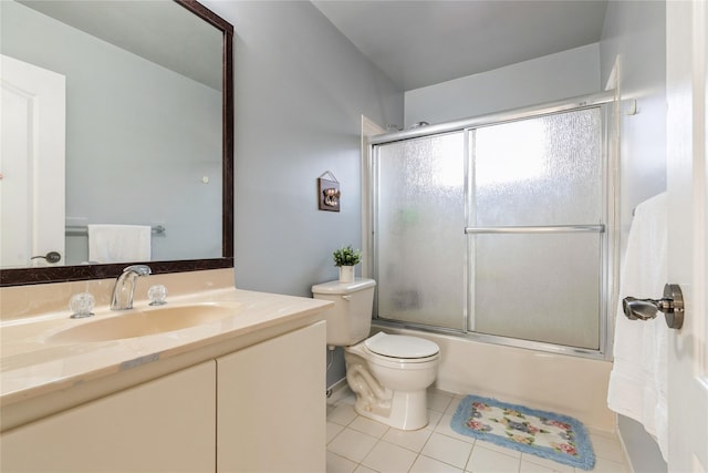 full bathroom featuring tile patterned flooring, shower / bath combination with glass door, vanity, and toilet