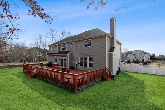 back of house featuring a wooden deck, a chimney, fence, and a yard